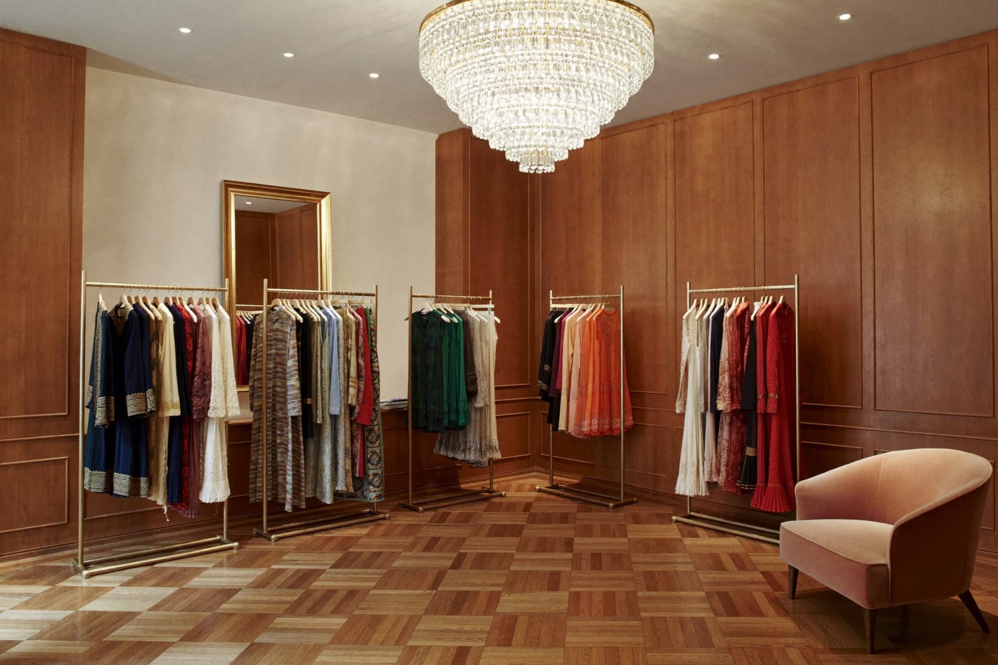Inside a Kabul Fashion boutique — racks of handmade dresses under a chandelier.