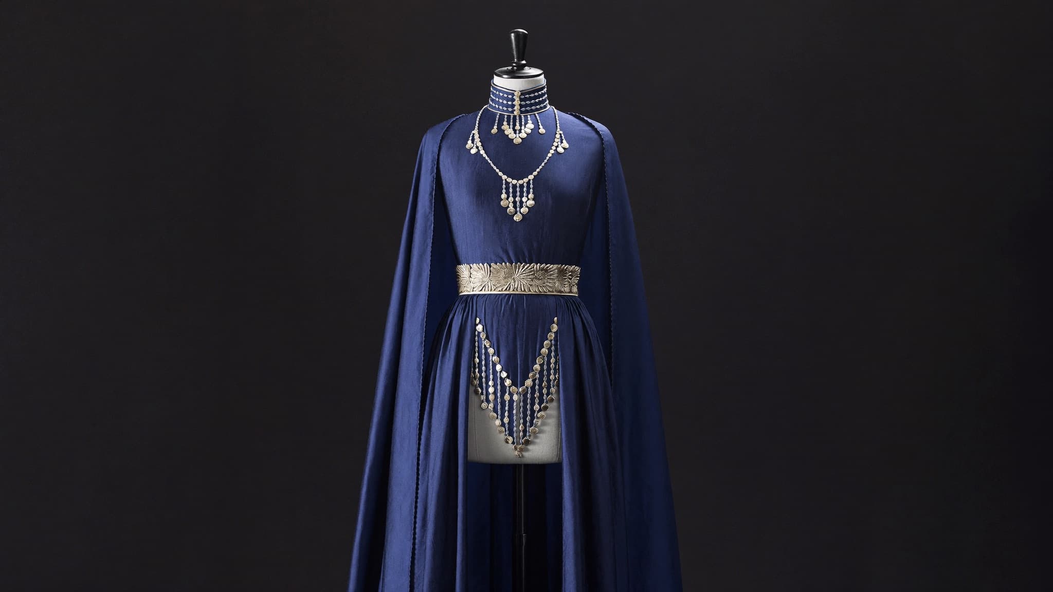 Rose-gold Afghan gown with gold embroidery, styled for an engagement portrait.