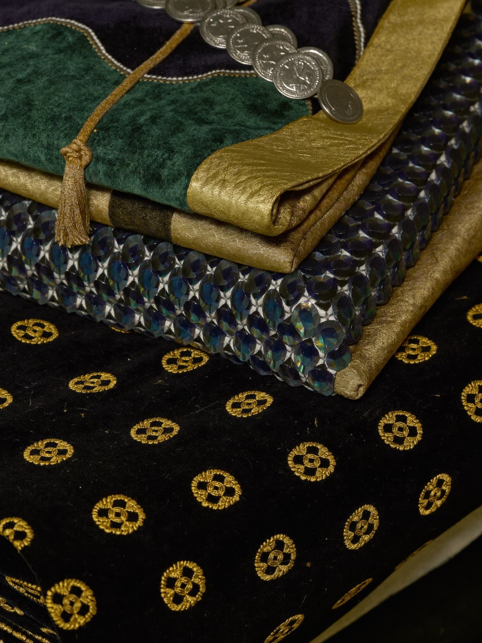 Folded glass-bead shawls and velvet trimmed with coins.