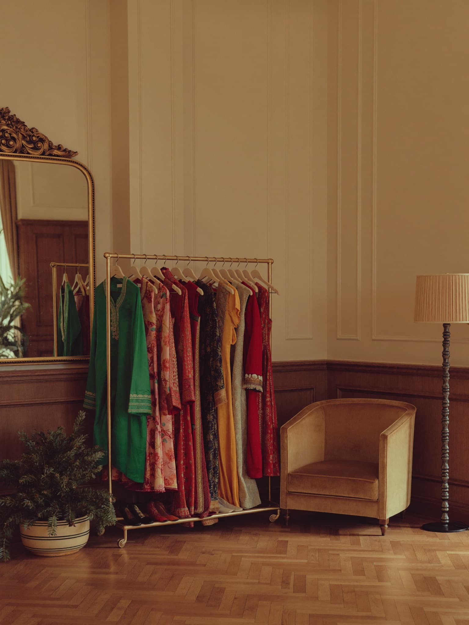 Editorial boutique with Afghan dresses on a rail, folded textiles, and a measuring tape.